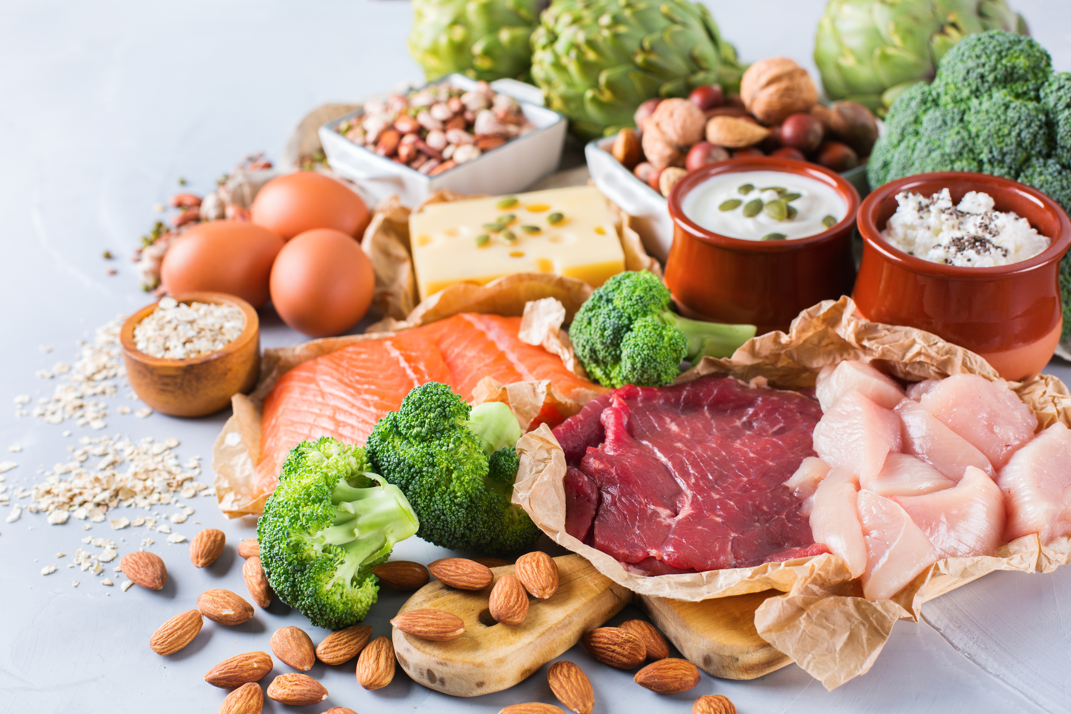 Assortment of healthy protein source and body building food. Meat beef salmon chicken breast eggs dairy products cheese yogurt beans artichokes broccoli nuts oat meal